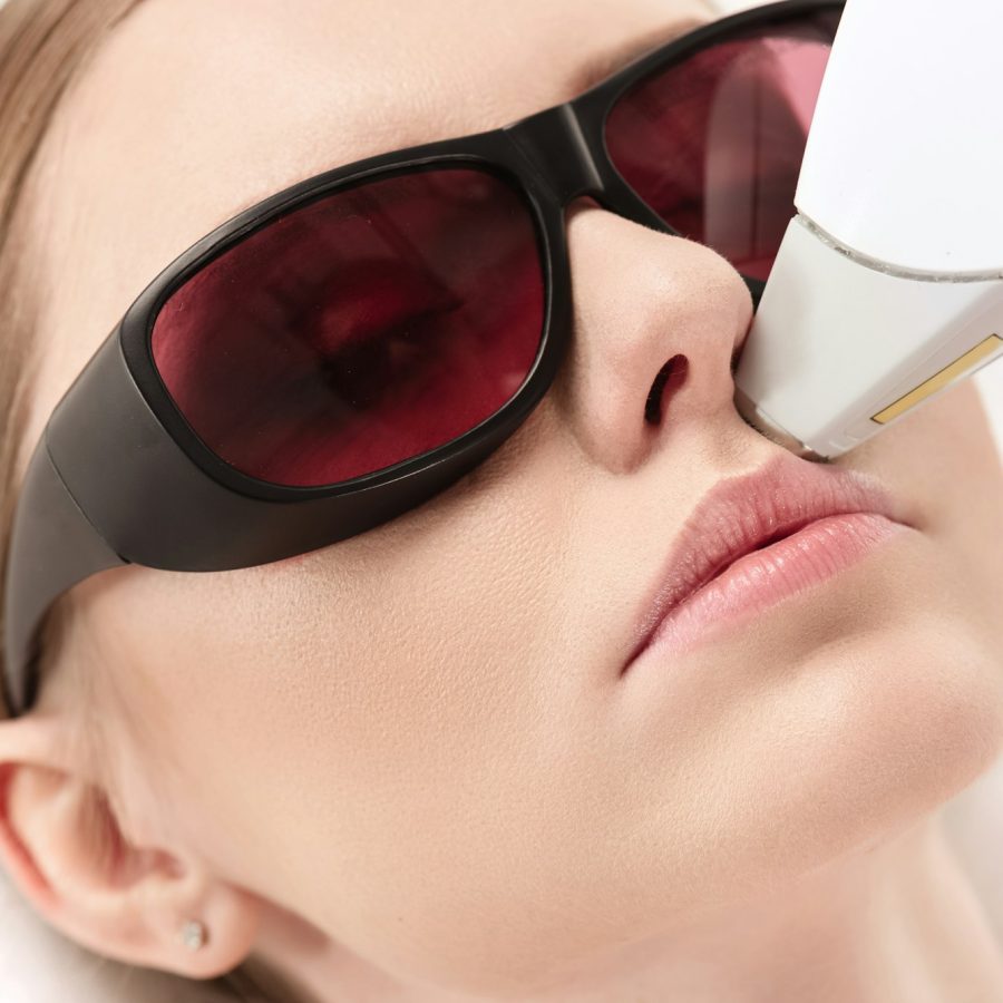 young woman receiving laser hair removal epilation on face. laser skin care concept